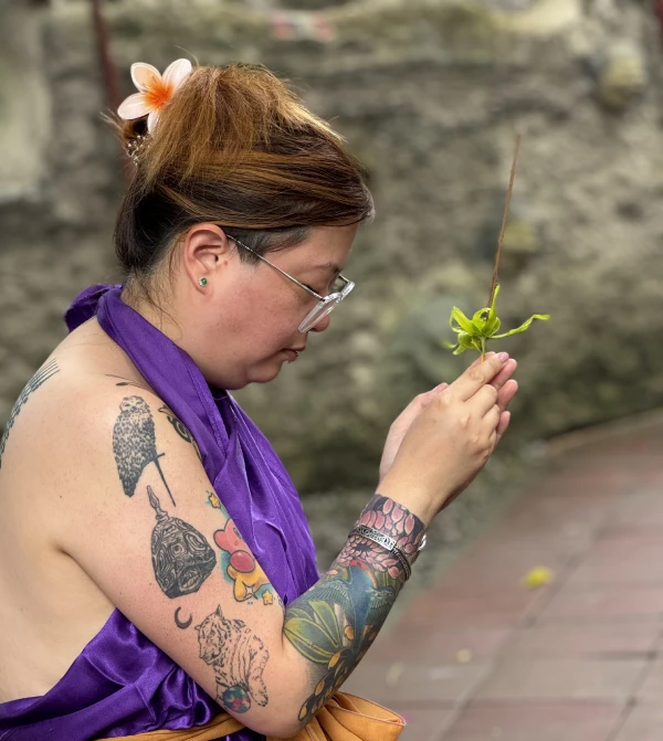 a girl holding leaf and wood while praying