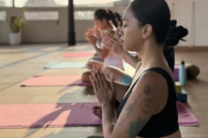 Women practicing mindfulness and meditation in an open-air yoga studio at sunrise
