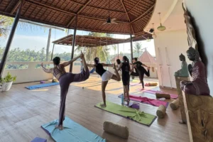 Group yoga class in an open-air tropical studio with scenic jungle views