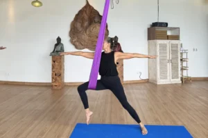 Graceful aerial yoga session using silk hammocks.