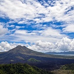 Cyclists enjoying a scenic ride around Mount Batur, surrounded by lush landscapes and breathtaking views
