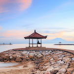 Breathtaking sunrise over Sanur Beach in Bali, illuminating the sky with vibrant colors and reflecting on the calm waters