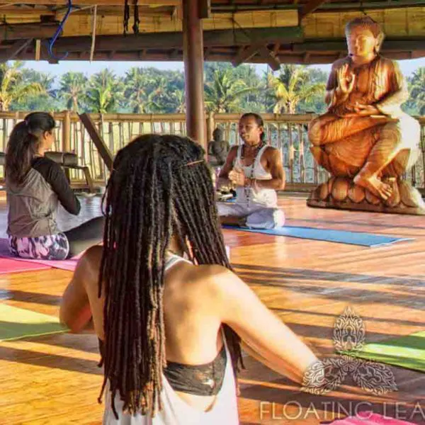 Yoga and meditation session at a Balinese retreat with a large Buddha statue