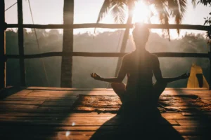 A woman practicing meditation in a serene tropical setting