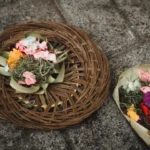 Traditional Balinese Canang Sari offering with flowers and incense.