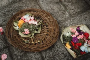 Traditional Balinese Canang Sari offering with flowers and incense.