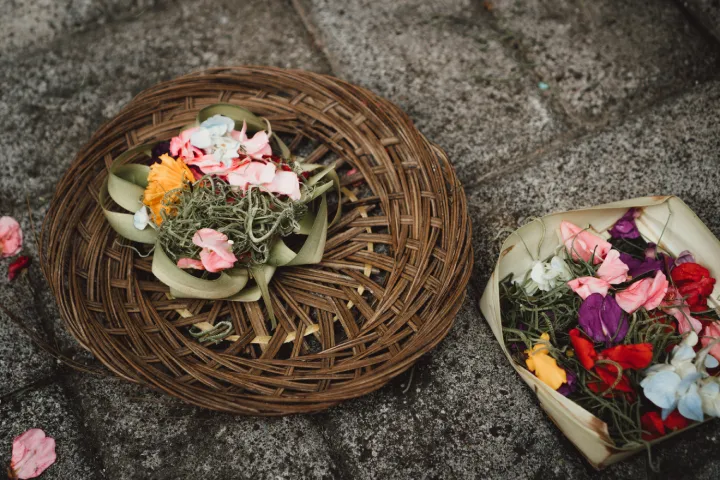 Traditional Balinese Canang Sari offering with flowers and incense.