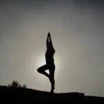 doing yoga pose with sun as background