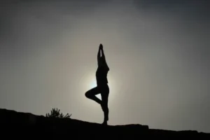 doing yoga pose with sun as background