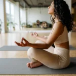"Woman in meditation pose during silent retreat yoga session with natural light"